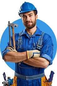 A construction worker wearing a blue hard hat, blue coveralls, and gloves stands with arms crossed, holding a hammer and wrench, smiling confidently against a blue circle background.
